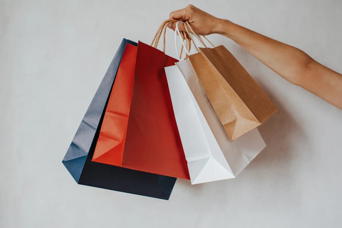 Colorful shopping bags held up in one hand